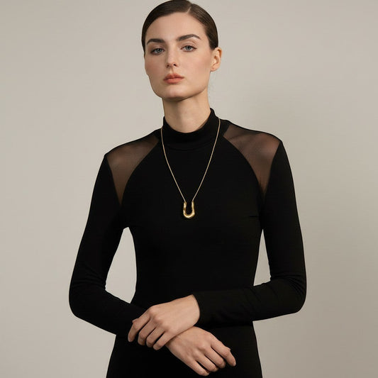 PRO RAY ELORA gold sculptural pendant necklace with fluid organic curves on a fine chain. Contemporary statement jewelry.