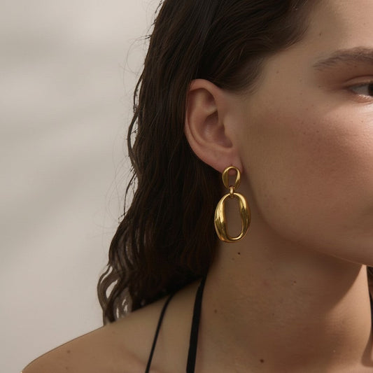 PRO RAY ORINA sculptural open oval drop earrings in polished gold finish. Modern elegance.