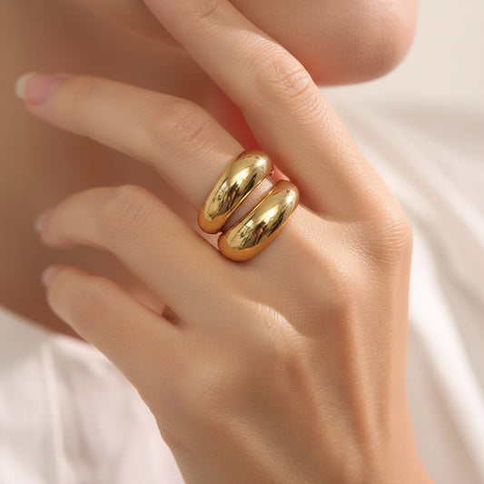 PRO RAY SERAVIA Ring: A bold, polished gold sculptural ring with flowing curved lines and an open silhouette.