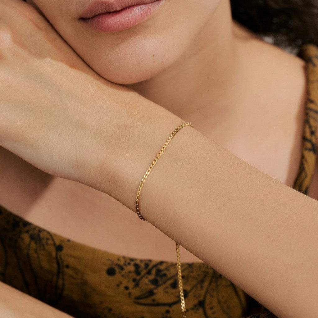 PRO RAY AELORA delicate gold chain bracelet with polished bead accents on a woman's wrist.