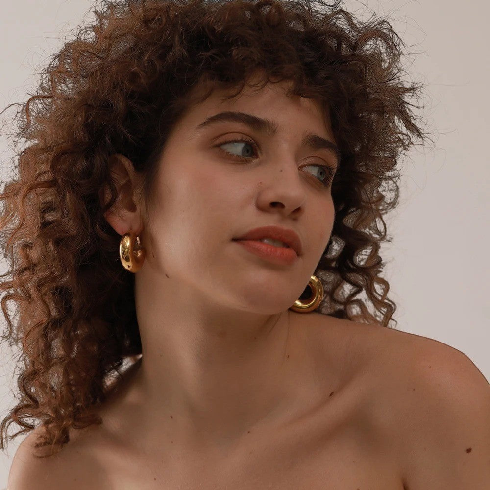 PRO RAY AENYA thick rounded gold hoop earrings, 25mm diameter, polished finish.