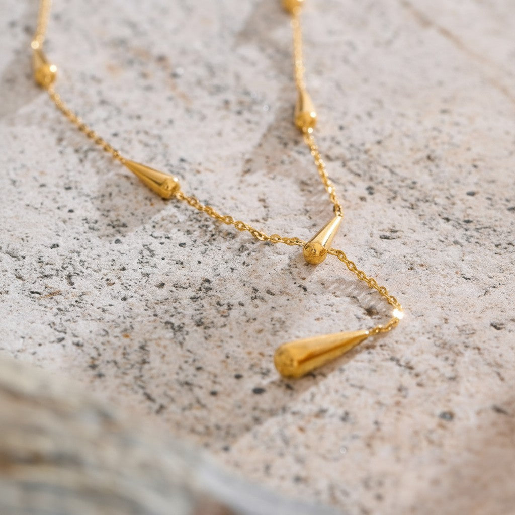 PRO RAY AIRA gold necklace with drop-shaped accents on a delicate chain. Modern elegance.