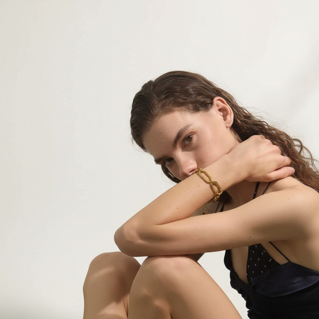 PRO RAY AUREVA gold chain bracelet with textured sculptural links, worn by a model.