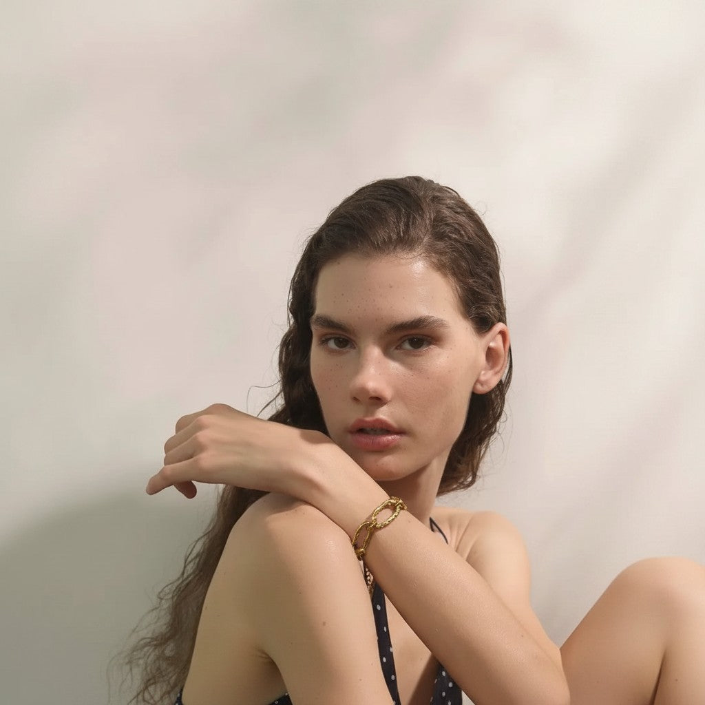 PRO RAY AUREVA gold chain bracelet with textured sculptural links, worn by a model.