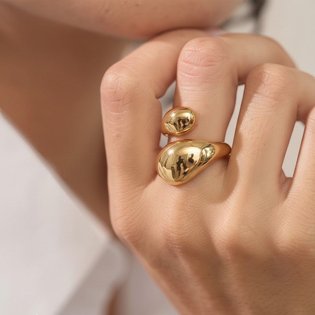 PRO RAY ELORIA ring: a sculptural open ring with smooth organic curves and a bold polished gold silhouette.