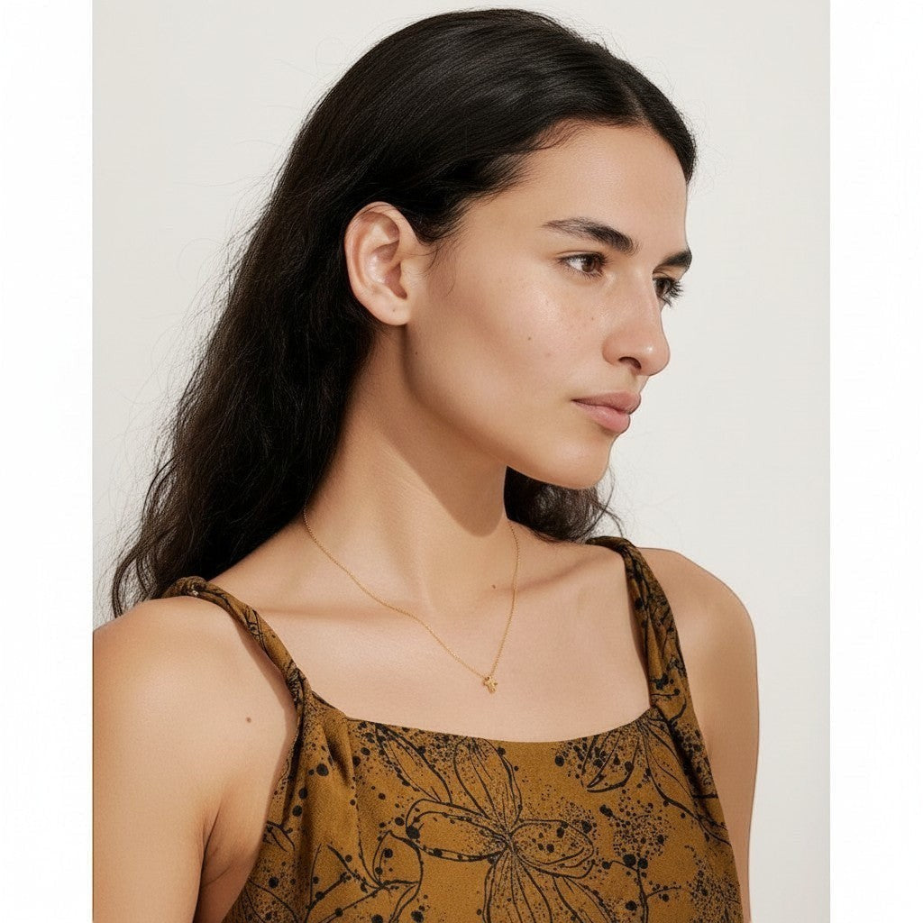 PRO RAY NAYLA delicate gold cross pendant necklace on a thin chain, worn by a model.