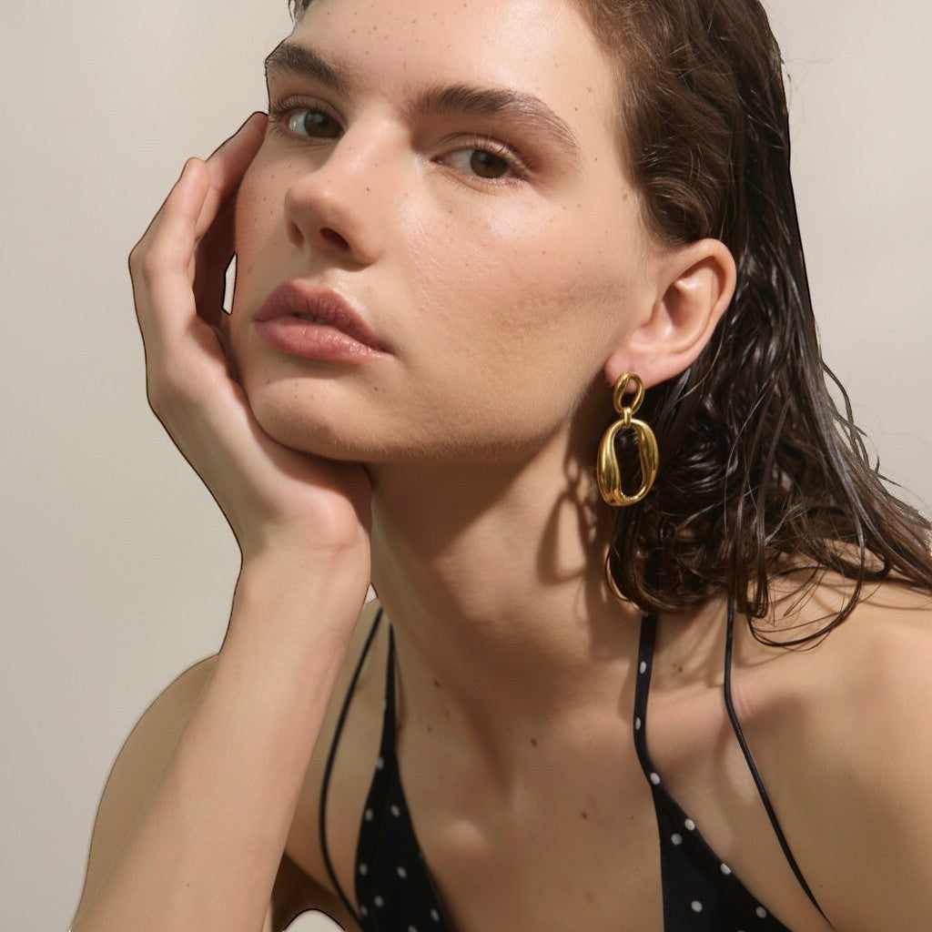 PRO RAY ORINA sculptural open oval drop earrings in polished gold finish.