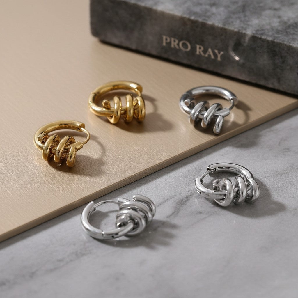 PRO RAY SELENE sculptural spiral hoop earrings in gold and silver, polished finish, 22mm diameter.