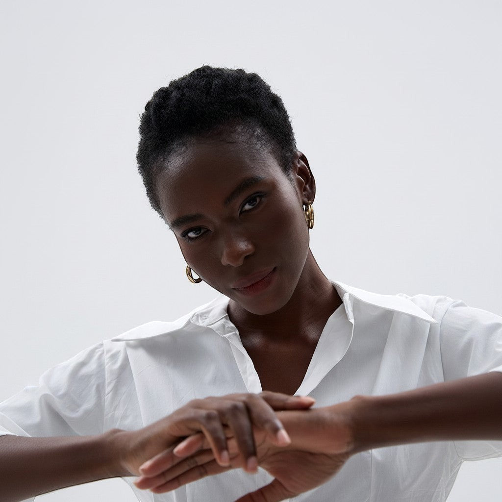 PRO RAY ZARIA gold twisted hoop earrings with sculptural silhouette, 31mm diameter, worn by a model.